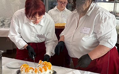 Auszubildende servieren Sahnetorte