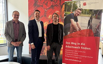 Otto Knauer, Dr. Christian Fischer und Bernhard Zwick stehen in einem Büro neben einem Roll-Up.
